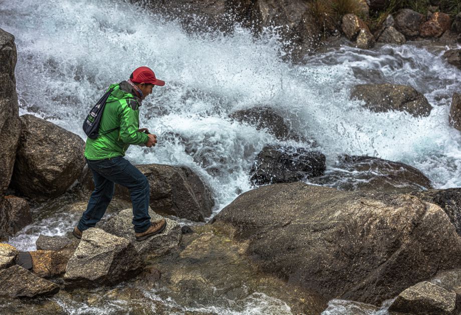 Saúl läuft auf Steinen vor einem reißenden Fluss